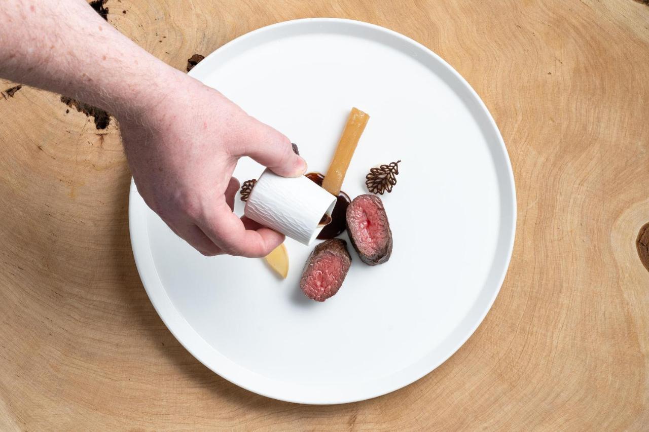 Boringdon Hall Hotel And Spa Plymouth Exterior photo A hand seasoning a plate of food with a spice shaker
